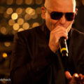 pitbull net worth, music, business & family 3 pitbull wearing sunglasses and singing into a microphone during walmart soundcheck