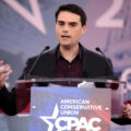 ben shapiro speaking at a cpac lectern with two microphones