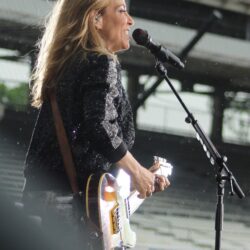 Sheryl Crow performing with guitar at the 2019 Indianapolis 500